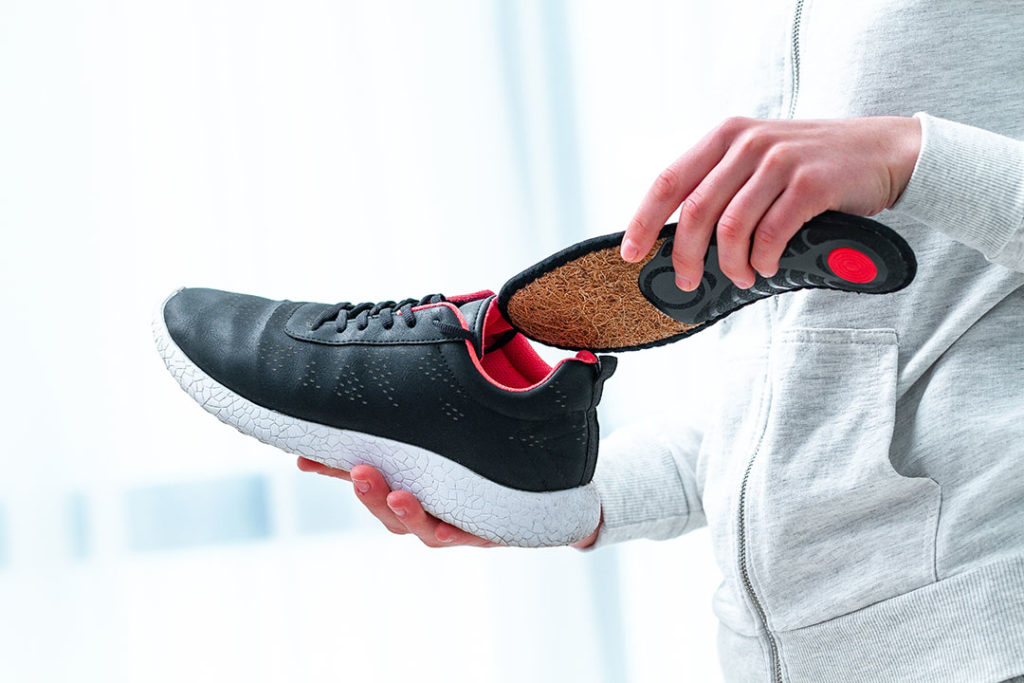 Man putting in insoles for running